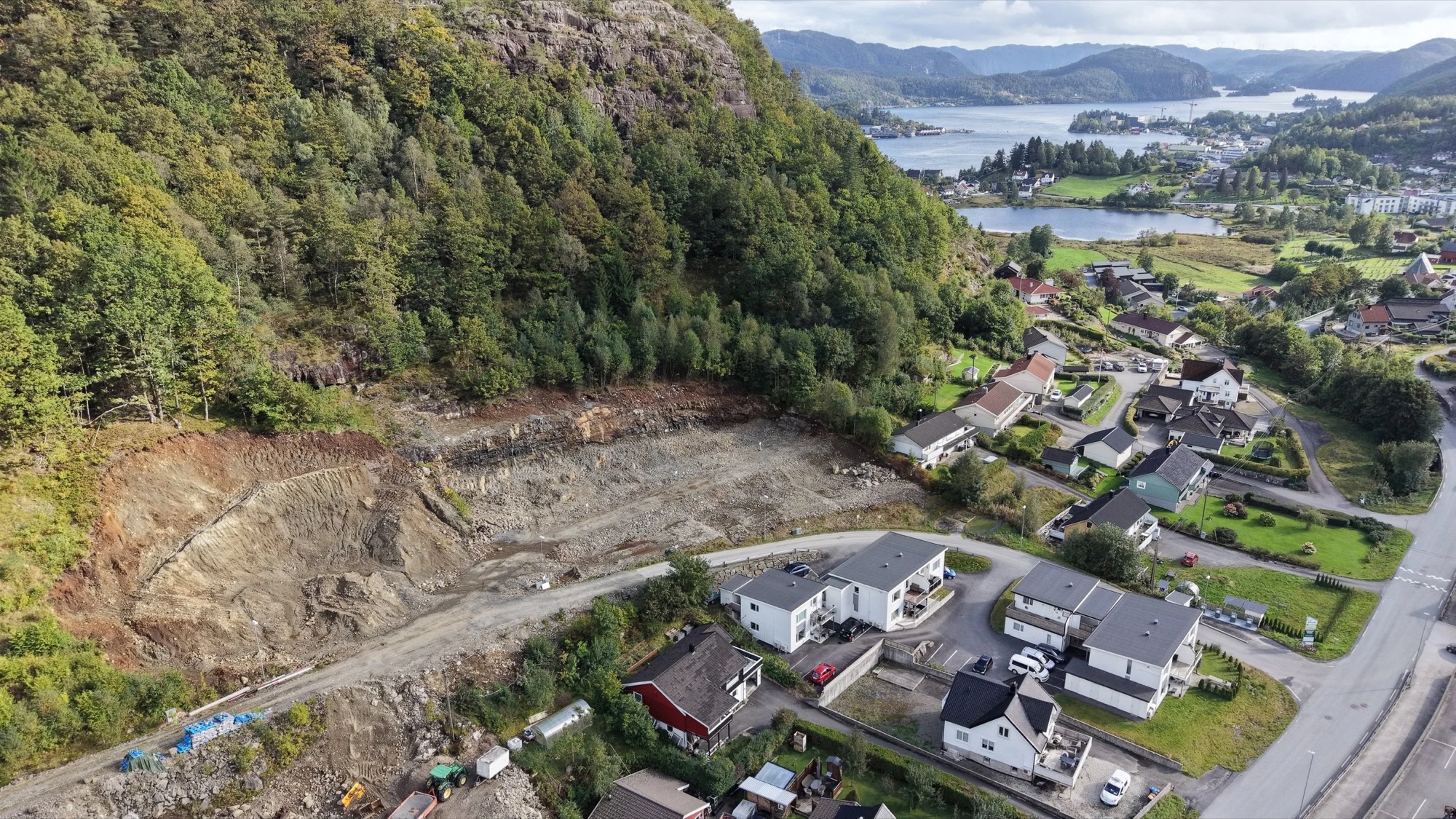Dronefoto av Søylandslia med grovplanerte tomter og utsikt mot Flekkefjord